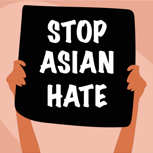 Peach and tan background with the arms of a person with medium brown skin holding a black sign with white letters that says Stop Asian Hate